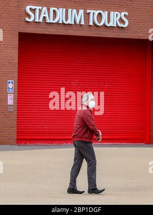 Ein Mann mit einer Gesichtsmaske (Abdeckung) geht vorbei an Anfield - Heimstadion der Premiership Tischkipper Liverpool. Heute hätte Liverpool ihr letztes Spiel der 19/20 Auswärtsspiel nach Newcastle im St James Park spielen sollen. Stockfoto