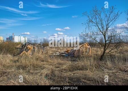 Zerstörte Gewächshäuser für Gemüse stehen auf einem Feld mit Gras des letzten Jahres überwuchert Stockfoto