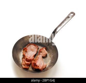 Gusseiserne Bratpfanne mit zwei Speckraschern auf weißem Hintergrund Stockfoto