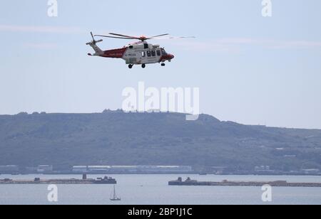 Ein AgustaWestland AW189 Hubschrauber von HM Coastguard fliegt über Weymouth Bay in Richtung Isle of Portland. Stockfoto