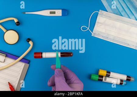 Flache Lay-Komposition mit Blutprobe auf blauem Hintergrund. Stockfoto