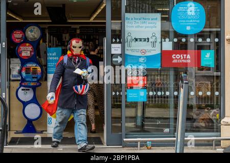 London, Großbritannien. Mai 2020. Ein Mann in einer Iron man Maske stellt sich Schlange und kauft dann im CO-OP in der Munster Road ein - wo jeder ein "lokaler Held" ist, wenn er 2 m von anderen entfernt ist. Die "Lockdown" geht weiter für den Ausbruch des Coronavirus (Covid 19) in London. Kredit: Guy Bell/Alamy Live News Stockfoto