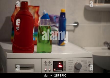 Waschmaschine im Badezimmer. Waschmittelbehälter aus Kunststoff und Beutel auf der Waschmaschine. Nahaufnahme. Stockfoto