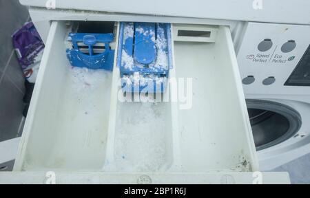 Getrocknetes Reinigungsmittel und Schmutz auf der Waschmittelschublade der Maschine. Nahaufnahme. Stockfoto