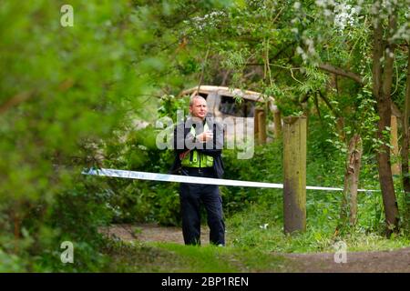 Ein Tatort Offizier bewacht ein ausgebranntes Fahrzeug in Shillington, wo der Fahrer des Unfalles das Fahrzeug floh. Stockfoto