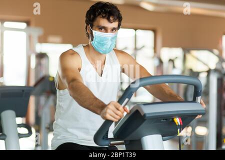 Mann in der Turnhalle trainieren seine Beine tun Cardio-Training auf dem Fahrrad Stockfoto