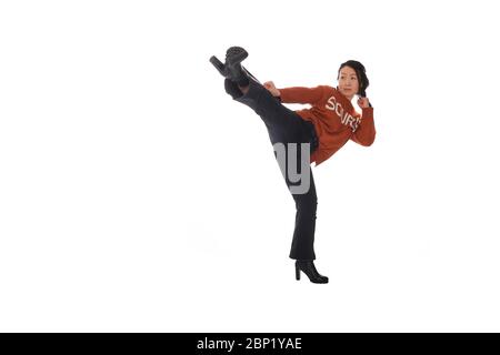 Asiatische junge Frau, die Kampfkunst in alltäglichen lässigen Straßenkleidung Stockfoto