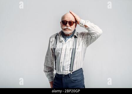 Älterer Mann mit Schnurrbart posiert in Sonnenbrille Stockfoto