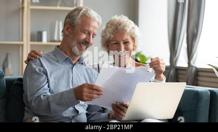 Glücklich mittleren Alters Familie Paar durch Papierdokumente zu suchen. Stockfoto