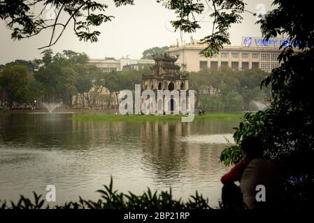 Unkenntlich Mann, der Hoan Kiem See und der Schildkrötenturm, in der Dämmerung, Hanoi, Vietnam aufgenommen Stockfoto