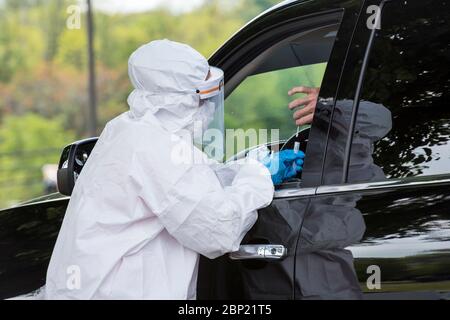 Soldaten der West Virginia National Guard und das Gesundheitsministerium des Bezirks Berkeley nehmen an einer COVID-19-Teststelle für Coronavirus Drive-Thru-Tests an der South Middle School am 15. Mai 2020 in Martinsburg, West Virginia, eine Abstrichprobe von einem Patienten. Stockfoto