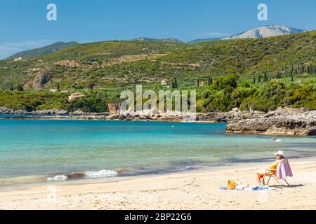 Touristen Genießen Sie die Sonne am Strand von Kalogria, in der Nähe Kardamyli Stadt, in Western Mani, Messinia Region, Peloponnes, Griechenland. Stockfoto