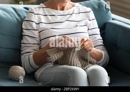 Nahaufnahme ältere Rentnerin Stricken Schal oder Pullover. Stockfoto