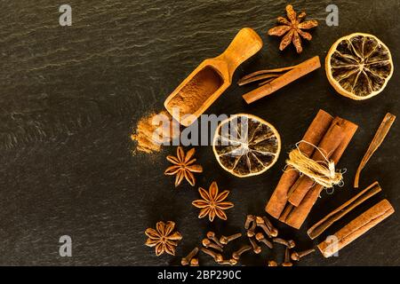 Traditionelle Weihnachtsgewürze - Sternanis mit Zimt und Nelken auf Schiefer. Aromatische Gewürze. Stockfoto