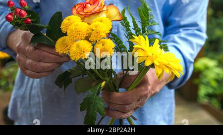 Nahaufnahme von älteren Frauen Hände mit einem Blumenstrauß Stockfoto