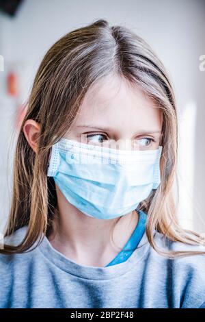 12-jähriges Mädchen, das während der Pandemie von Covid 19 eine Schutzmaske trägt. Stockfoto
