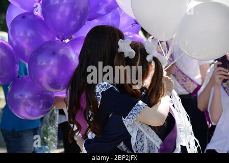 Zwei Schülerinnen in Vintage Schuluniform mit hellen Ballons auf der Graduierung Stockfoto