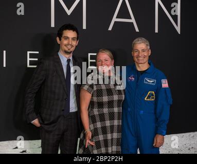 Premiere von "First man" am NASM NASA-Astronaut Mark Vande Hei, rechts, und seine Frau Julie, Mitte, posieren für Foto mit Regisseur und Produzent Damien Chazelle bei der Premiere von Universal's Spielfilm "First man" Donnerstag, 4. Oktober 2018 im Smithsonian National Air and Space Museum in Washington. Der Film basiert auf dem Buch von Jim Hansen, das das Leben des NASA-Astronauten Neil Armstrong vom Testpilot bis zu seiner historischen Mondlandung dokumentiert. Regie führte Damien Chazelle mit Ryan Gosling und Claire Foy. Stockfoto