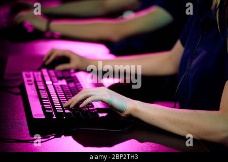 Hände der jungen weiblichen Betreiber des Call-Center berühren Tasten der Computer-Tastatur, während Beratung eines Kunden oder Videospiel Stockfoto