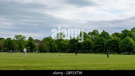 Harrogate, North Yorkshire, Großbritannien. Mai 2020. Drei Freunde spielen Fußball auf dem Grün in der Mitte der Stadt, als die Lockdown Maßnahmen gelockert werden. Kredit: ernesto rogata / Alamy Live News Stockfoto