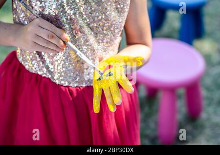 Glücklich Kind Malerei mit Pinsel farbenfrohe Bild auf ihre Hand und Finger Stockfoto