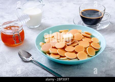 Pfannkuchen-Müsli mit Butter in Schale auf grauem Stein Tisch. Trendiges Food-Konzept. Stockfoto