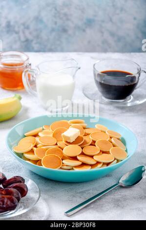 Pfannkuchen-Müsli mit Butter in Schale auf grauem Stein Tisch. Trendiges Food-Konzept. Stockfoto