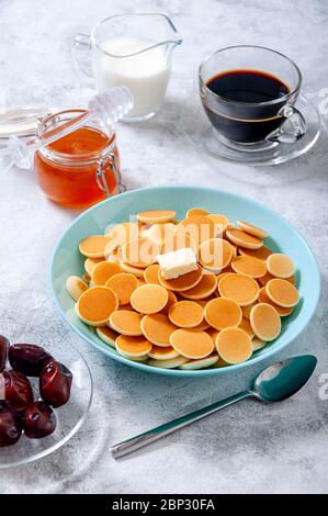 Pfannkuchen-Müsli mit Butter in Schale auf grauem Stein Tisch. Trendiges Food-Konzept. Stockfoto