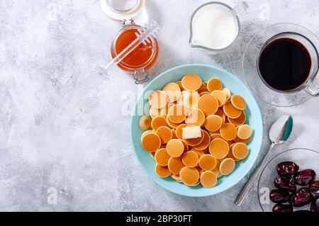 Pfannkuchen-Müsli mit Butter in Schale auf grauem Stein Tisch. Trendiges Food-Konzept. Flaches Lay. Stockfoto