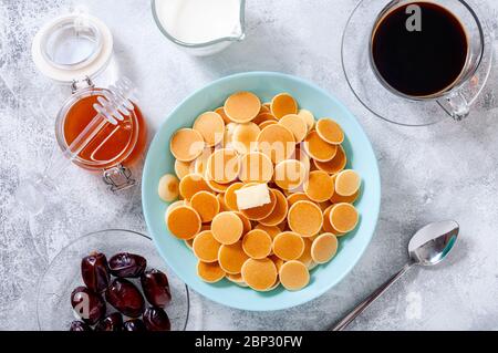 Pfannkuchen-Müsli mit Butter in Schale auf grauem Stein Tisch. Trendiges Food-Konzept. Flaches Lay. Stockfoto