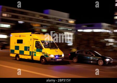 Londoner Notarztwagen, der nachts mit blauen Lichtern und Bewegungsunschärfe in London, England, Großbritannien, reagiert Stockfoto