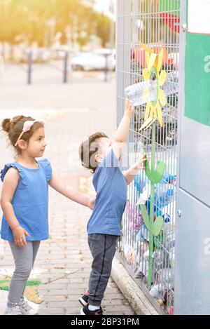 Junge Werfen Recycling Kunststoff-Botllen Im Papierkorb Container Mit Müll. Helfen Im Umweltfreundlichen Außenbereich. Konzept Plastic Free World, Zero Waste. Einstellen. Foto 2. Stockfoto