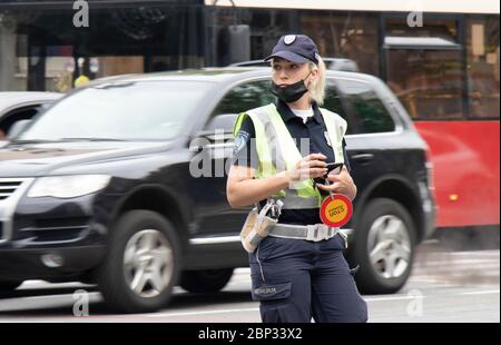 Belgrad, Serbien - 15. Mai 2020: Polizistin im Dienst, die am Schnittpunkt mit dem Verkehr in Bewegung steht, verschwimmt Stockfoto