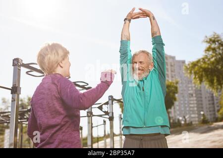 Gesunde Lebensweise. Schöne ältere oder ältere Familie Paar in Sportbekleidung tun Dehnungsübungen zusammen am frühen Morgen im Outdoor-Fitnessstudio Stockfoto