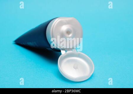 Offenes Rohr woth Creme auf blauem Hintergrund Nahaufnahme Stockfoto