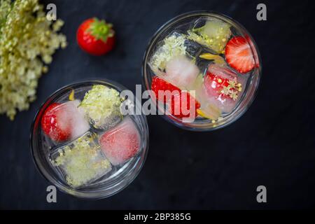 Gin Tonic mit Eldehußwürfeln und strawbery garnieren Stockfoto