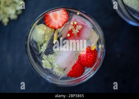 Gin Tonic mit Eldehußwürfeln und strawbery garnieren Stockfoto