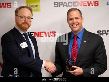 2019 SpaceNews Awards NASA-Administrator Jim Bridenstine nimmt die Readers’ Choice und SpaceNews Awards für die Government Agency of the Year im Namen der NASA entgegen.Brian Berger, Chefredakteur von SpaceNews, Dienstag, 10. Dezember 2019, während der 3. Jährlichen SpaceNews Awards in Hogan Lovells in Washington. Stockfoto