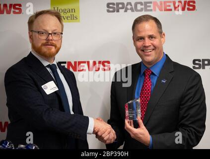 2019 SpaceNews Awards NASA-Administrator Jim Bridenstine nimmt den Readers’ Choice Award für den Leiter der zivilen Regierung des Jahres von Brian Berger, Chefredakteur von SpaceNews, Dienstag, 10. Dezember 2019, während der 3. Jährlichen SpaceNews Awards in Hogan Lovells in Washington entgegen. Stockfoto