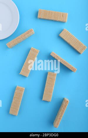 Leckere Wafer-Sticks auf blauem Hintergrund, flach liegend. Süßes Essen Stockfoto