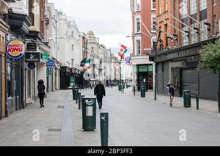 Fußgänger auf der verlassenen Grafton Street im Stadtzentrum von Dublin, während der Fußabsturz aufgrund der Coronavirus-Pandemie abstürzt. Covid-19 in Irland. Stockfoto