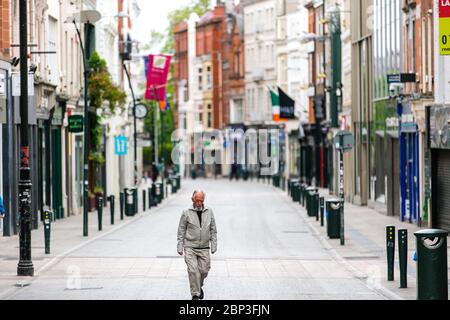 Ein älterer Mann, der durch die verlassene Grafton Street im Stadtzentrum von Dublin läuft, während der Fußabsturz aufgrund einer Coronavirus-Pandemie abstürzt. Covid-19 in Irland. Stockfoto