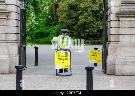 Dublin, Irland. Mai 2020. Aufseher, der am Eingang zum St. Stephen's Green Park in Dublin die Sicherheitsbeschilderung Yellow Coronavirus Covid-19 aufführt. Stockfoto