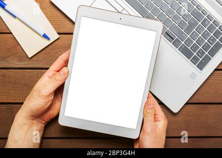 Hand mit leerem Bildschirm des digitalen Tablets auf dem Schreibtisch. Stockfoto