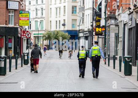 Dublin, Irland. Mai 2020. Zwei Garda-Offiziere auf Patrouille zu Fuß durch ruhige Grafton Street im Stadtzentrum von Dublin während Covid-19 Pandemiesperre. Stockfoto