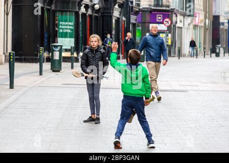 Die Familie spielt auf der verlassenen Grafton Street im Stadtzentrum von Dublin, da Geschäfte und Geschäfte geschlossen bleiben und aufgrund der Covid-19 die Besucherfrequenz sinkt. Stockfoto