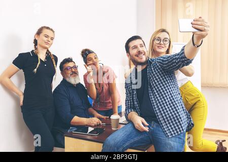 Glückliche multirassische Kollegen, die Selfie im Büro machen Stockfoto