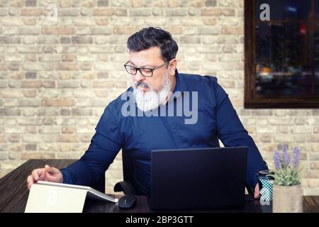 Gestresste gemischte Rennen Geschäftsmann an der Rezeption arbeitet spät im Büro Stockfoto