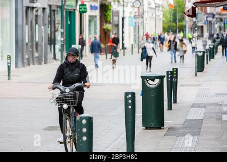 Fußgänger, die durch die ruhige Grafton Street im Stadtzentrum von Dublin gehen, da die Geschäfte geschlossen bleiben und der Fußabsturz aufgrund der Coronavirus-Pandemie abstürzt. Stockfoto