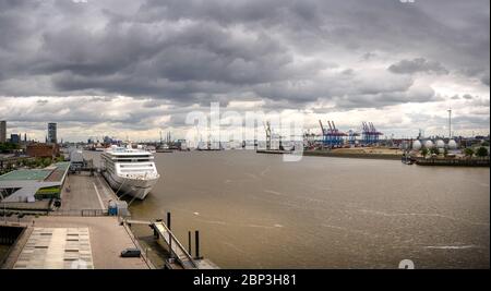 Panorama eines Containerterminals und Industrieanlagen im Hamburger Hafen mit einem Kreuzfahrtschiff Stockfoto